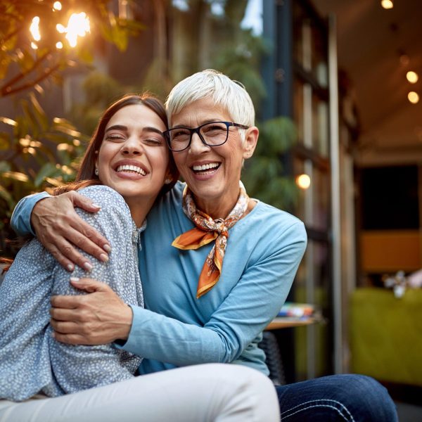 portrait of a senior mother and adult daughter, hugging, smiling. Love, affection concept